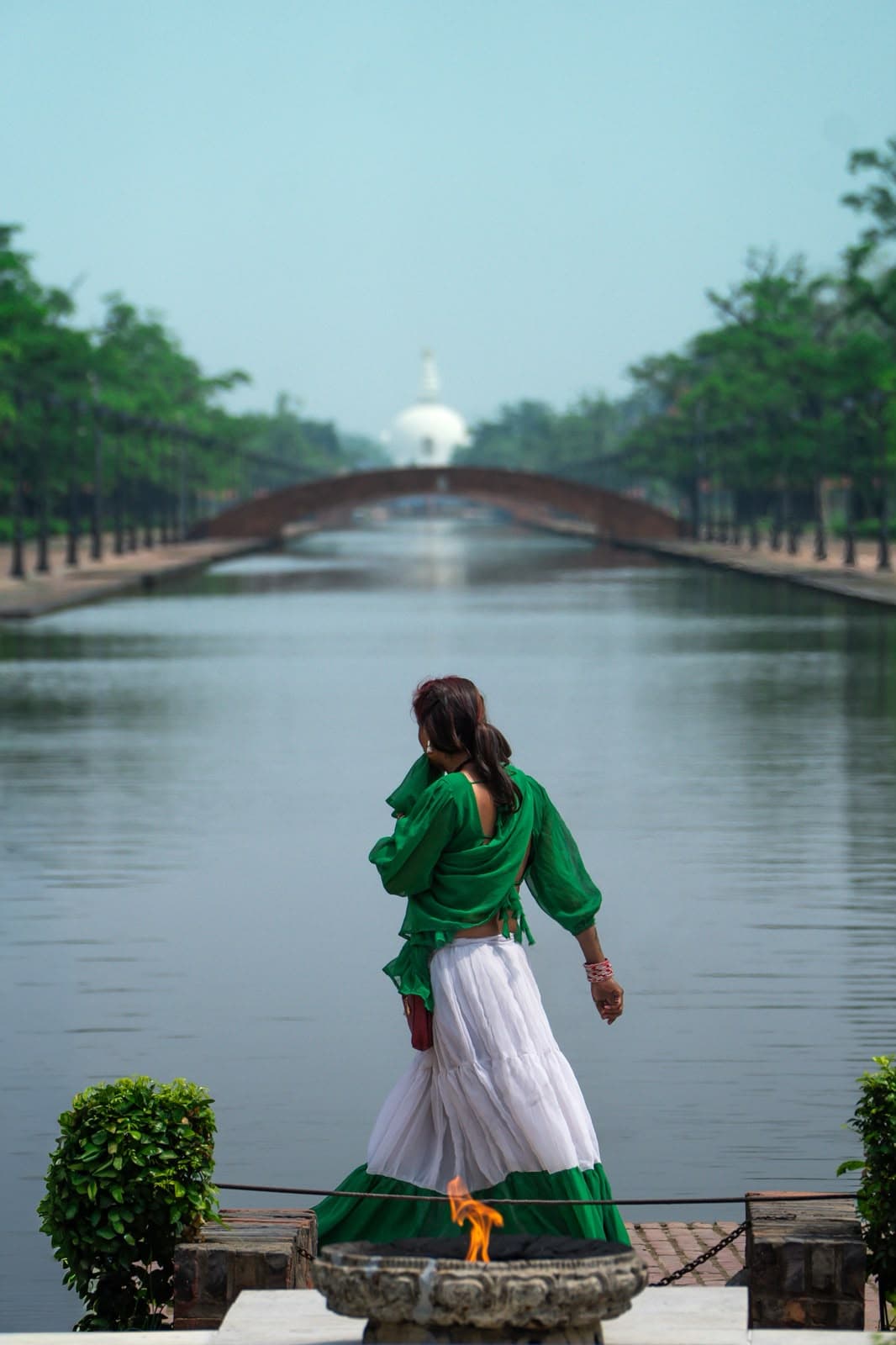 Woman walking beside a temple canal