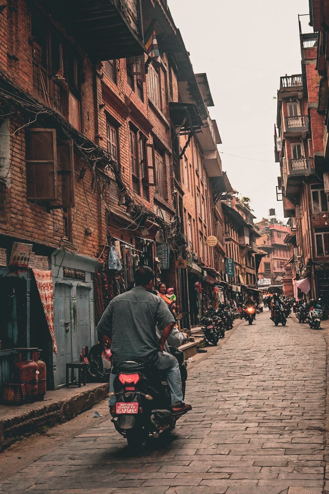A motorbike through a brick-lined street