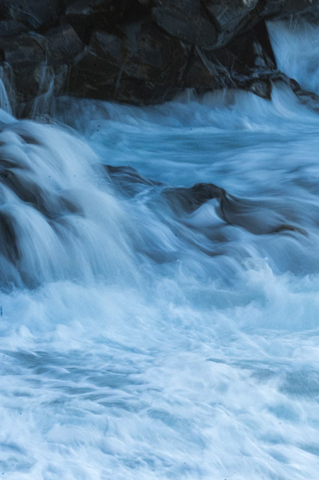 Water rushing over rocks, long exposure, blue dusk